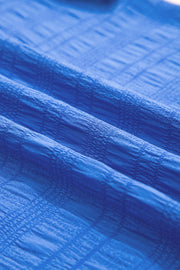 Top azul oscuro texturizado con mangas fruncidas y cuello redondo