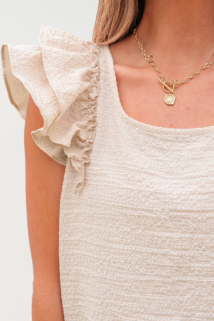 Blusa beige texturizada con lazo, volantes y mangas mariposa