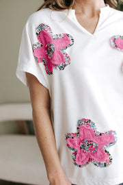 Blusa con cuello en V, mangas dolman y apliques florales blancos