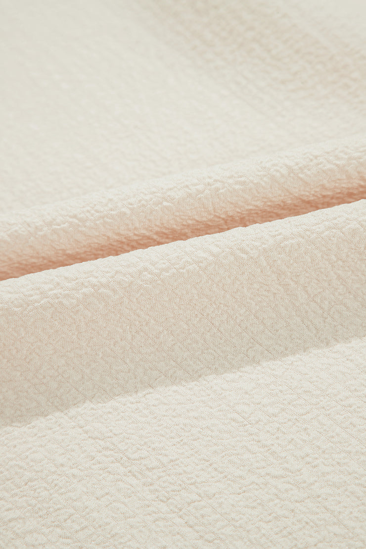 Blusa beige texturizada con lazo, volantes y mangas mariposa