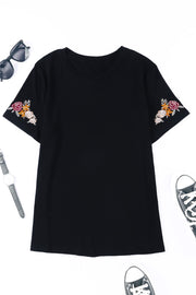 Camiseta negra de manga corta con cuello redondo y bordado floral
