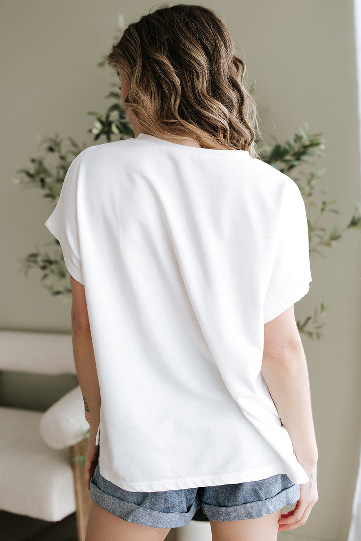 Blusa con cuello en V, mangas dolman y apliques florales blancos